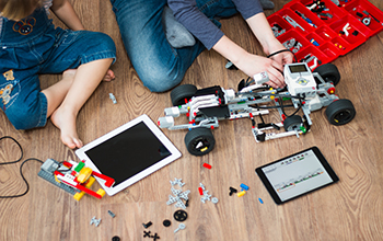 Two children work on a toy car.